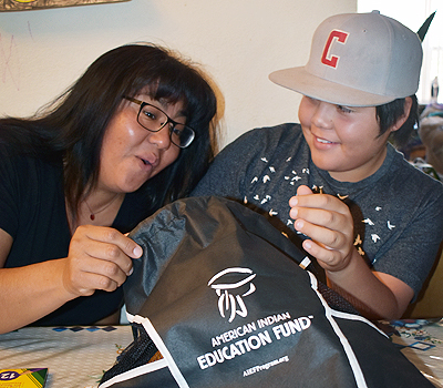 Dale, pictured with his mom, digs in to his AIEF backpack filled with school supplies