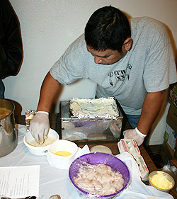 Crow Creek Head Start parent, Albert, prepares a meal for a National Relief Charities community event in Fort Thompson.